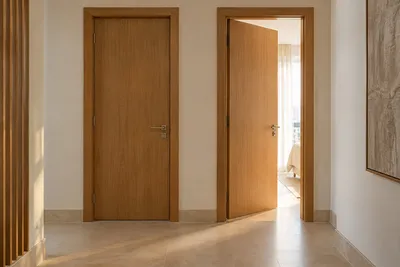 Corredor com duas portas, uma delas entreaberta com luz entrando